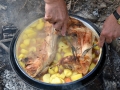 Top of the Vrshnik removed showing cooked wild rabbit and potatoes
