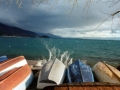 Boats upside down on the shore of Lake Ohrid with waves splashing ashore